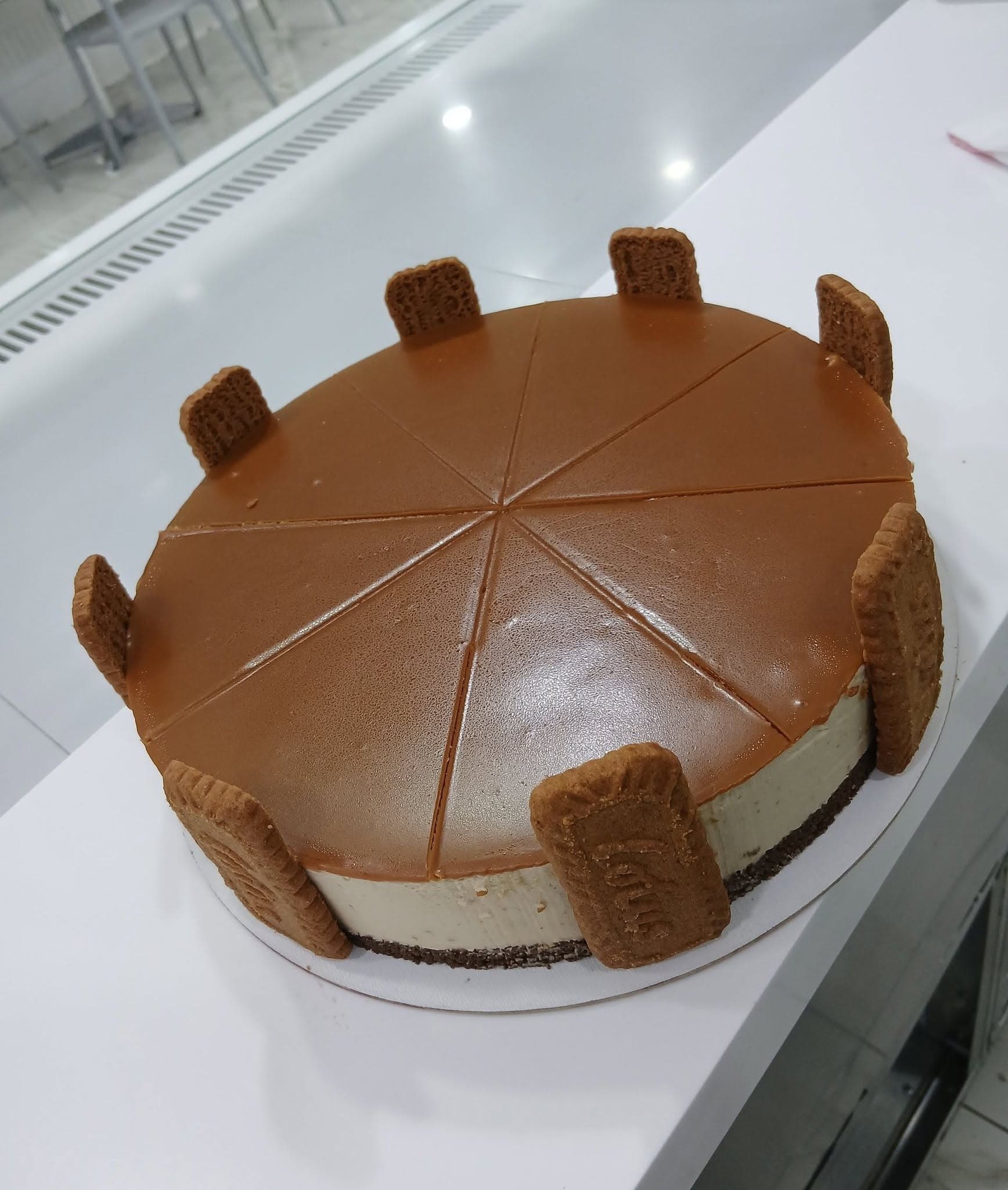 Cheesecake entier nappé de caramel, bordé de spéculoos
