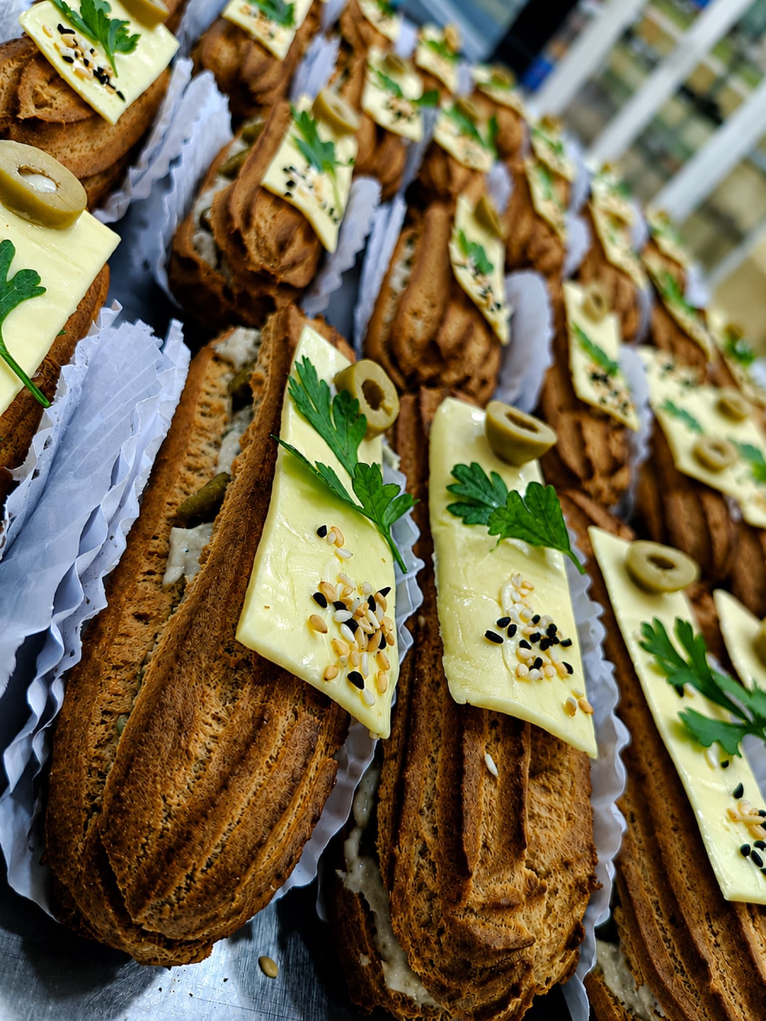 Éclairs salés garnis de fromage, olive et persil