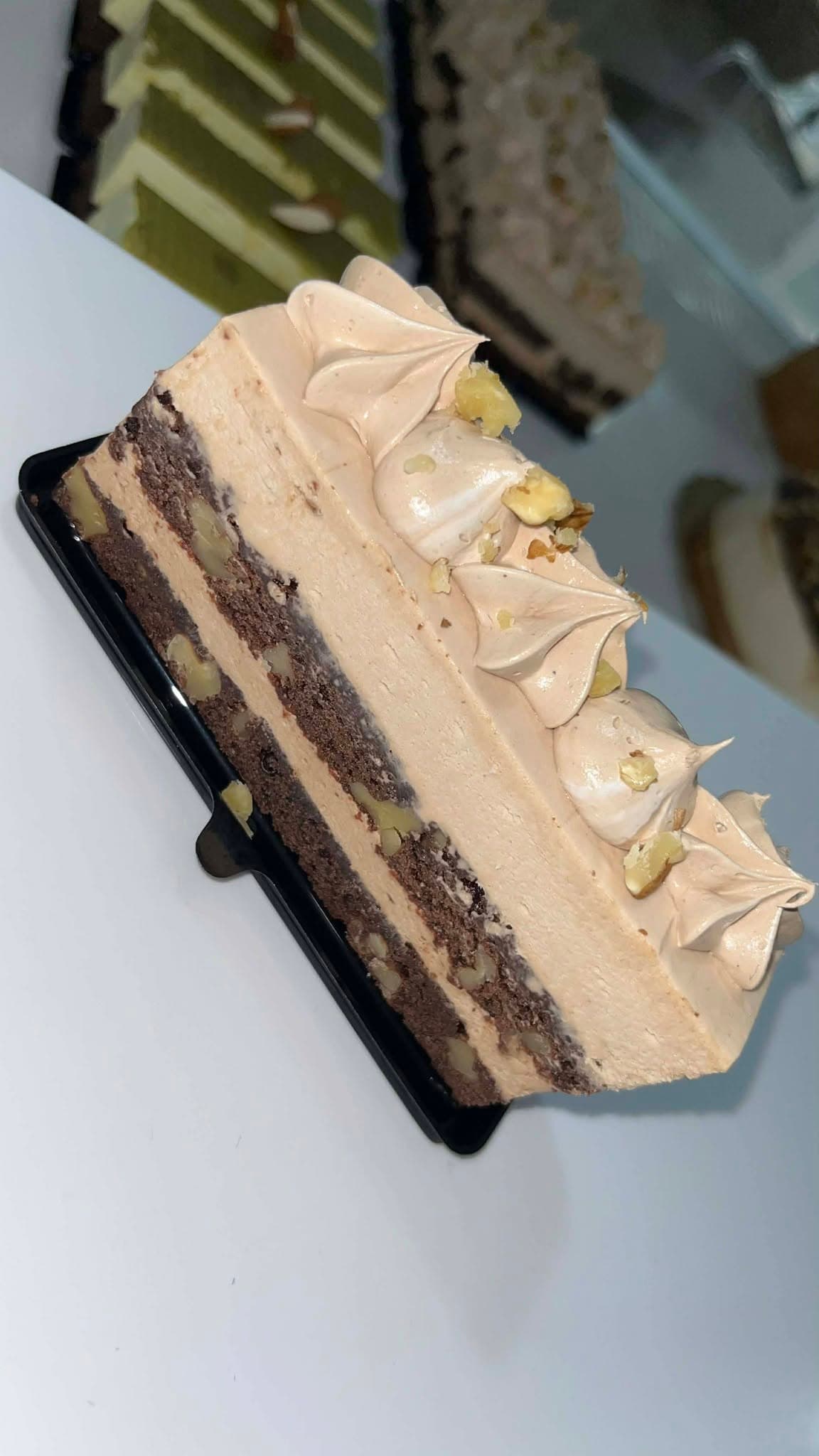 Part d’entremets praliné à trois étages, meringue et éclats de pistache