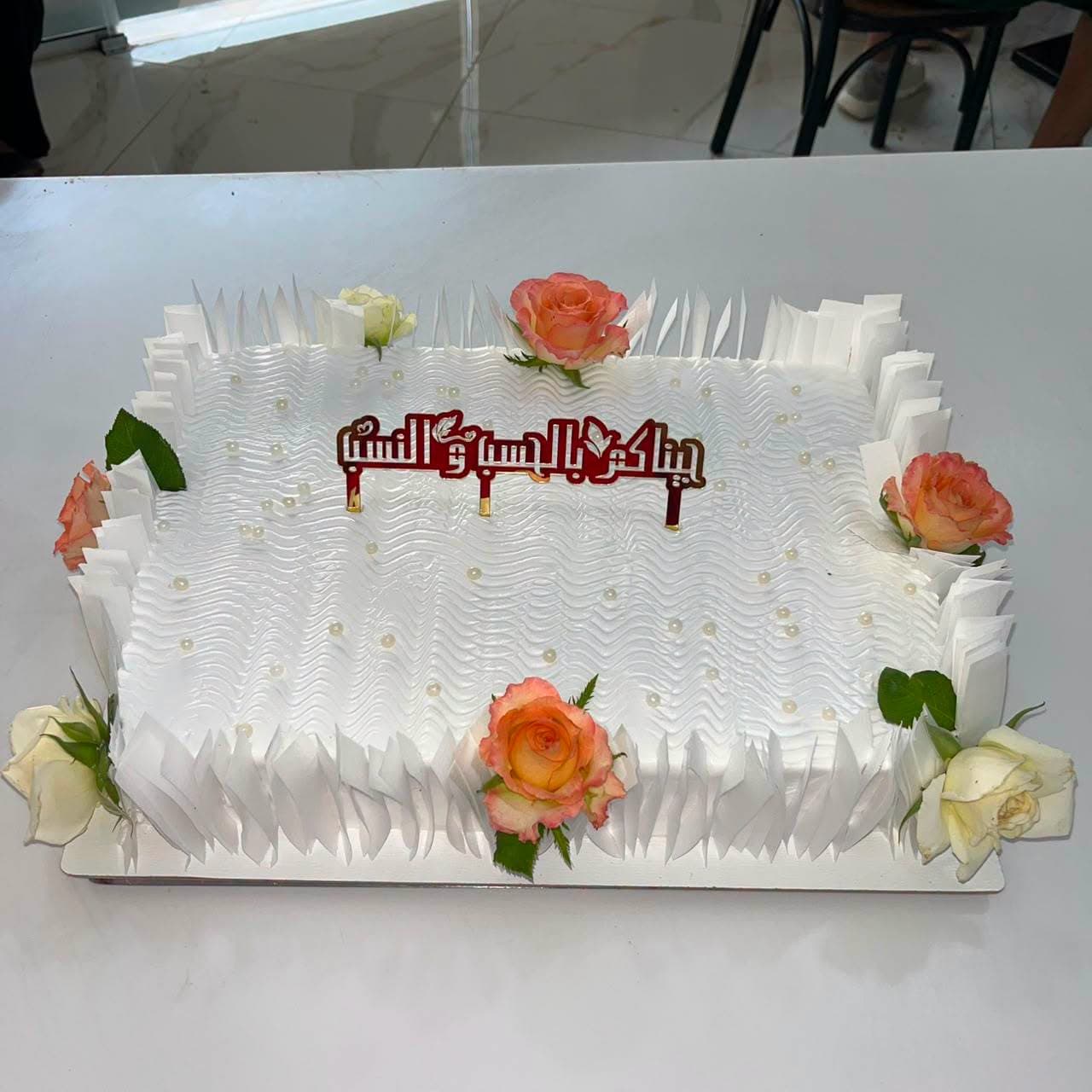 Grand gâteau de fiançailles décoré de roses et de calligraphie