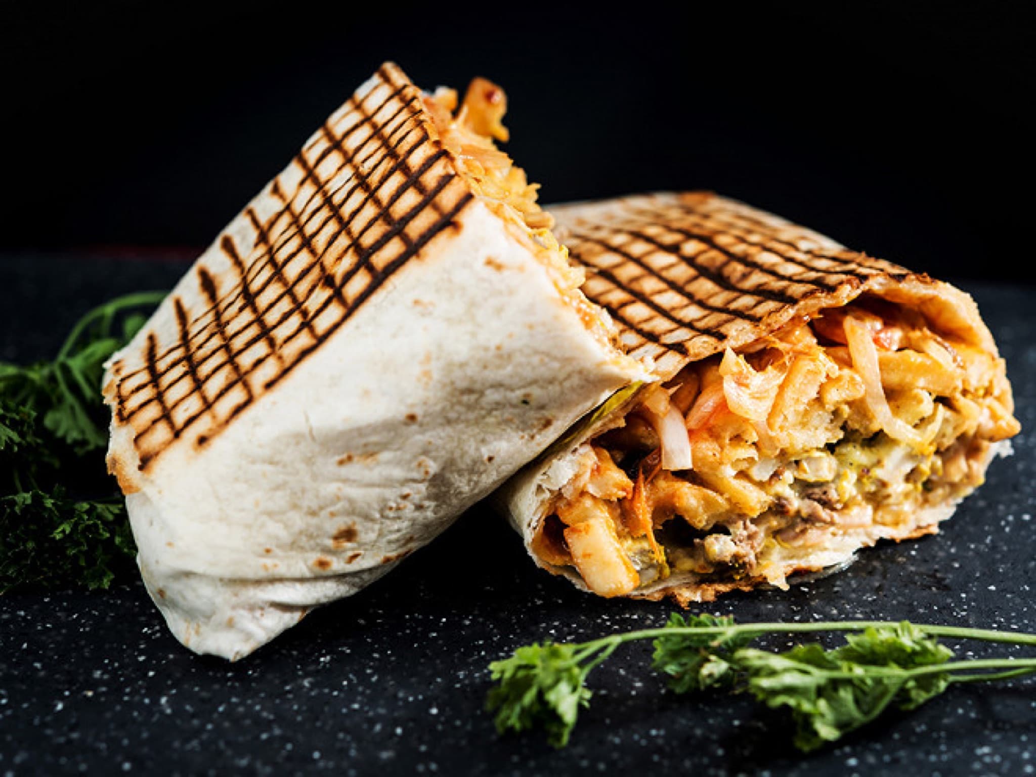 Tacos grillé et coupé, garni de viande et de frites