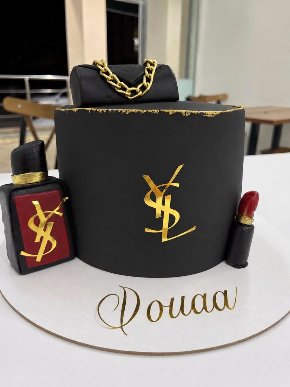 كعكة على شكل حقيبة وقارورة عطر وأحمر شفاه
